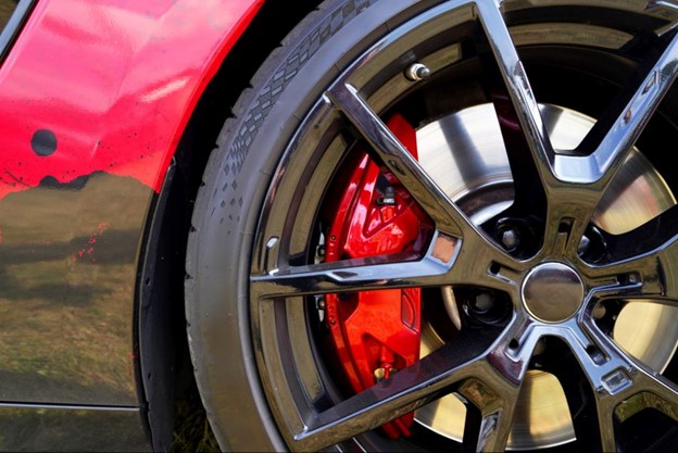 Close up shot of the front wheel of a Porsche being repaired